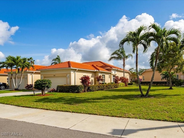 view of front of property with a garage, a front lawn, a tile roof, and stucco siding