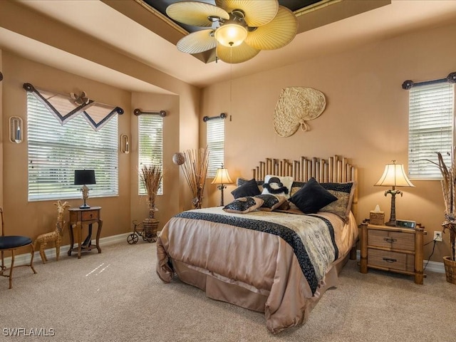 bedroom with light carpet, baseboards, and a ceiling fan