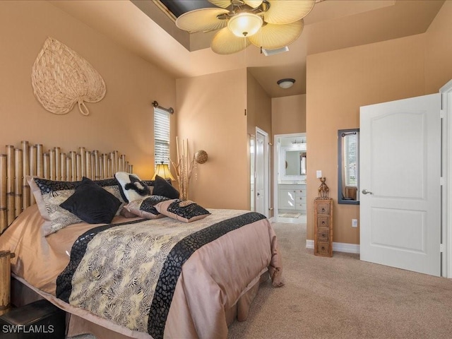 bedroom with visible vents, light carpet, ceiling fan, ensuite bath, and baseboards