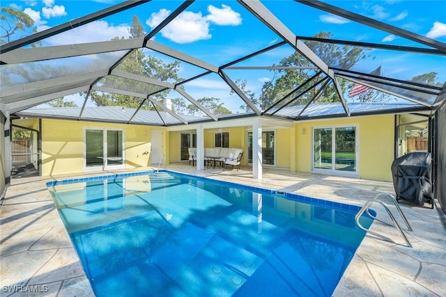 view of pool with a lanai, an outdoor hangout area, a grill, and a patio area