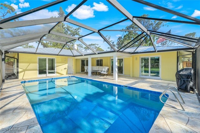 outdoor pool with outdoor lounge area, area for grilling, glass enclosure, and a patio area