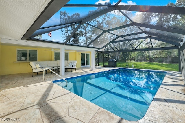 pool with a patio, an outdoor living space, a yard, ceiling fan, and a lanai