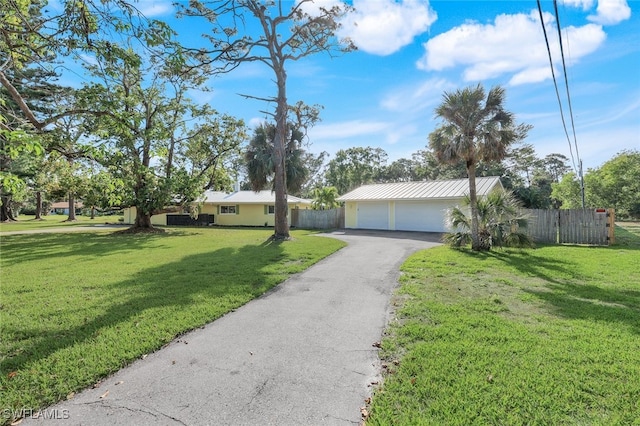 ranch-style home with a front lawn, fence, and metal roof