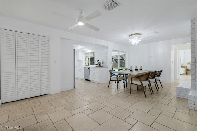 dining area featuring ceiling fan with notable chandelier