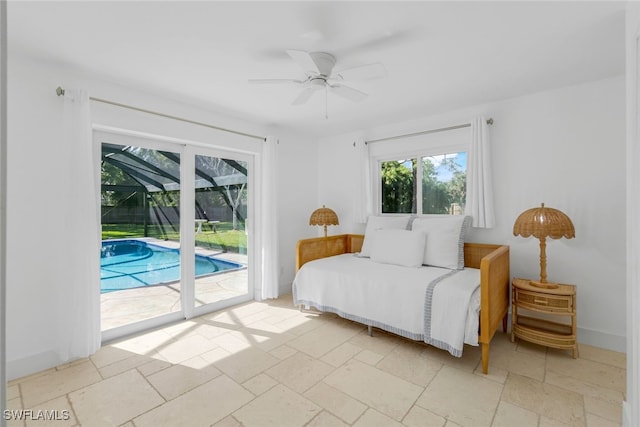 bedroom featuring stone tile floors, a ceiling fan, baseboards, a sunroom, and access to exterior