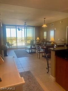 living room with floor to ceiling windows and light tile patterned floors