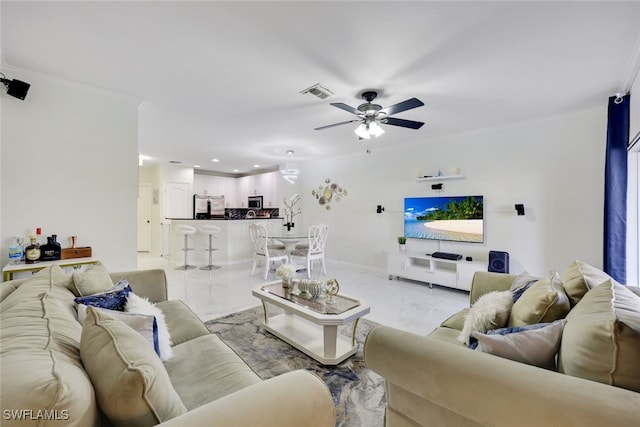 living room with ceiling fan and ornamental molding