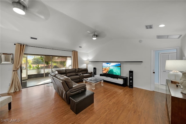 living room with ceiling fan, light hardwood / wood-style floors, and vaulted ceiling