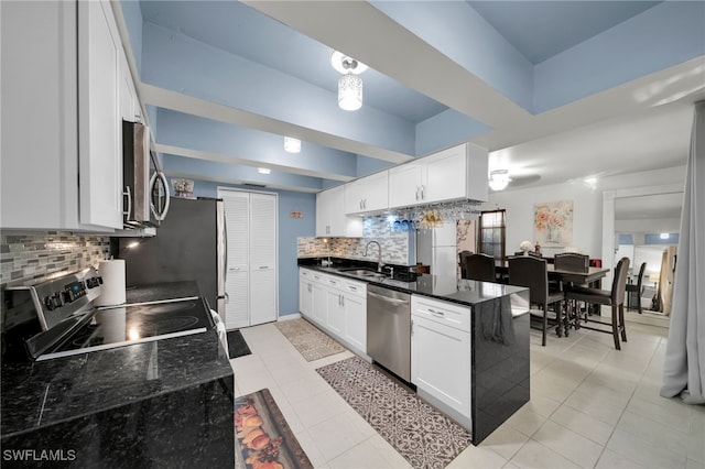 kitchen featuring light tile patterned flooring, appliances with stainless steel finishes, tasteful backsplash, white cabinetry, and sink