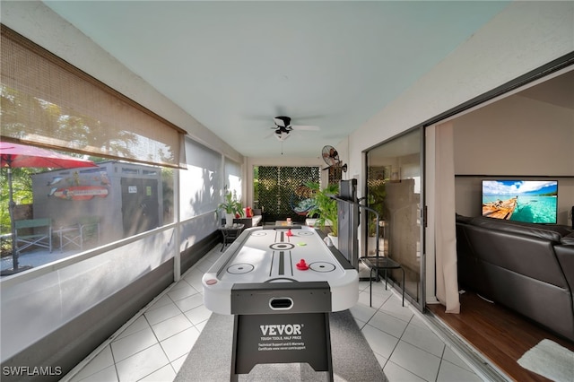 rec room with light tile patterned flooring and ceiling fan