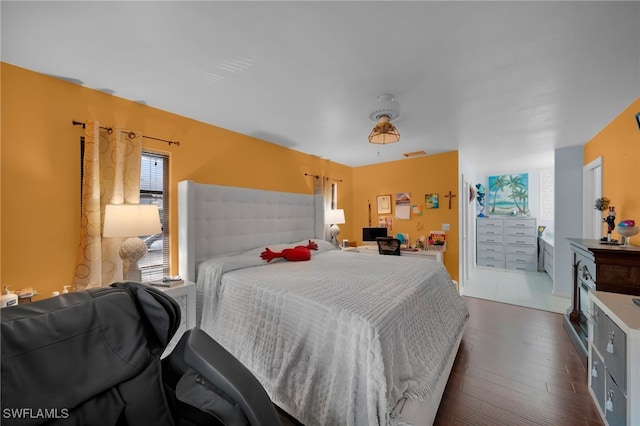 bedroom featuring multiple windows and dark hardwood / wood-style floors