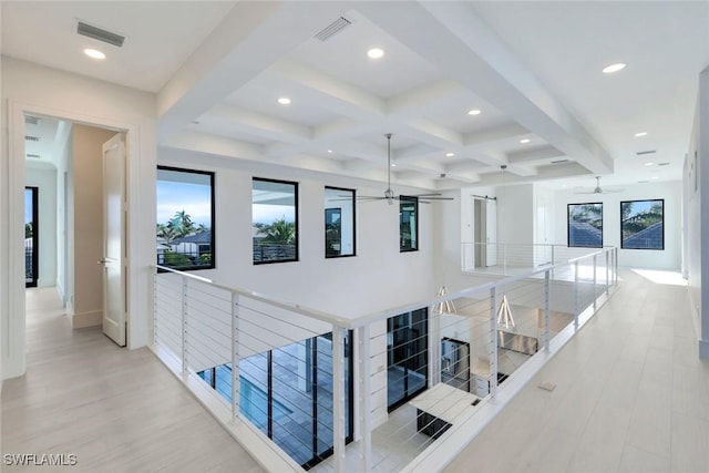 hallway with visible vents, beamed ceiling, and an upstairs landing