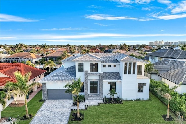 view of front of home featuring a garage, decorative driveway, a residential view, stucco siding, and a front yard