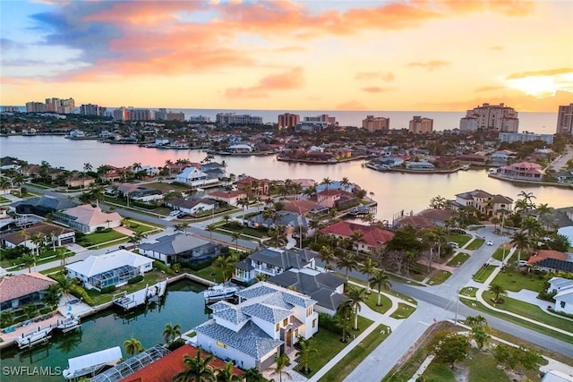 aerial view at dusk with a water view and a city view