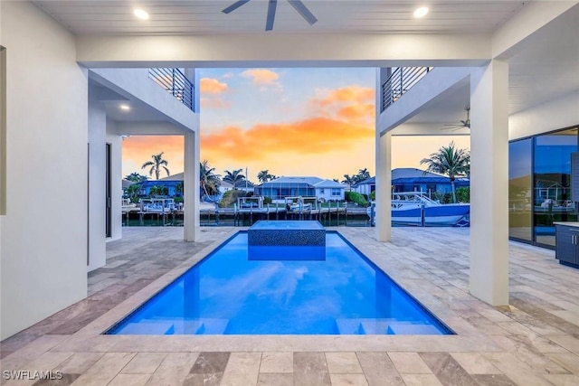 outdoor pool featuring a residential view, a ceiling fan, and a patio