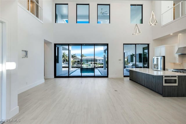 unfurnished living room featuring baseboards and light wood finished floors