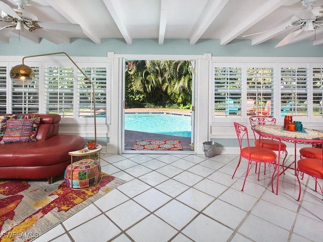 sunroom with ceiling fan, beam ceiling, and a wealth of natural light