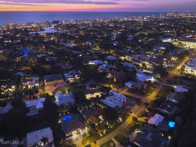 aerial view at dusk featuring a water view