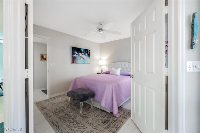 bedroom with light tile patterned floors, a ceiling fan, and baseboards