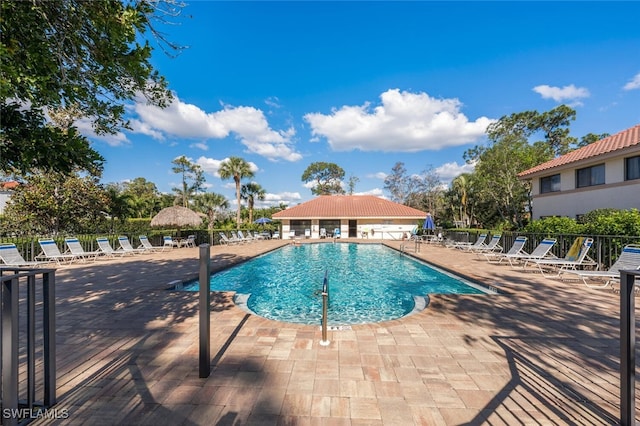 pool with a patio and fence