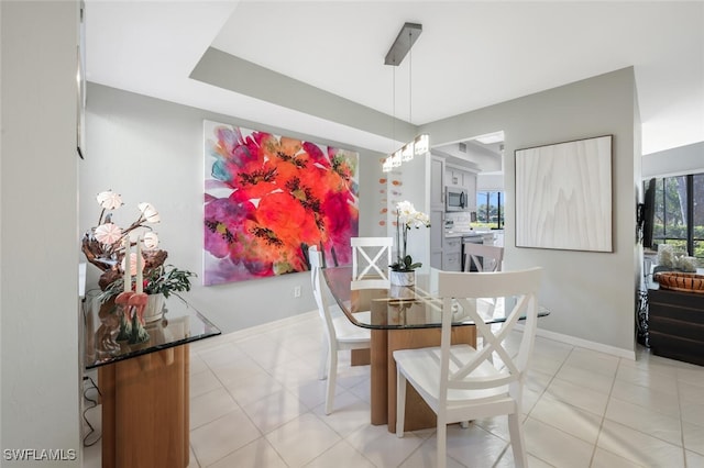 dining space featuring baseboards and light tile patterned floors