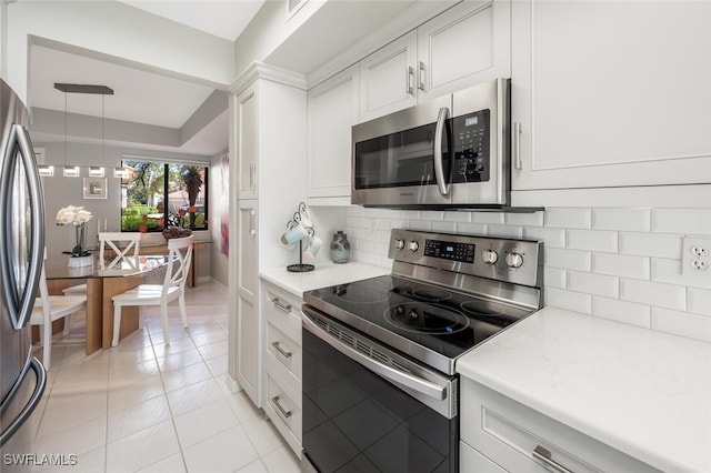 kitchen featuring stainless steel appliances, light tile patterned flooring, white cabinetry, and decorative backsplash