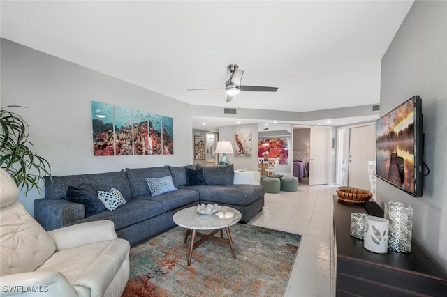 living area featuring a ceiling fan, visible vents, and light tile patterned floors