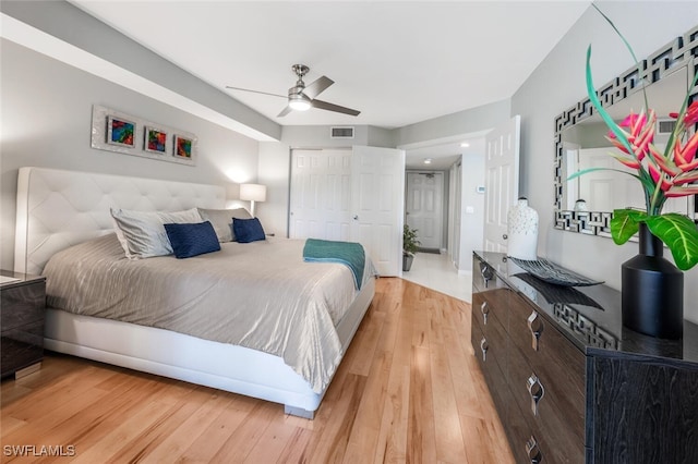 bedroom with a ceiling fan, a closet, visible vents, and light wood-style flooring