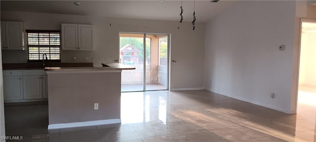 kitchen with dark countertops, baseboards, and a sink