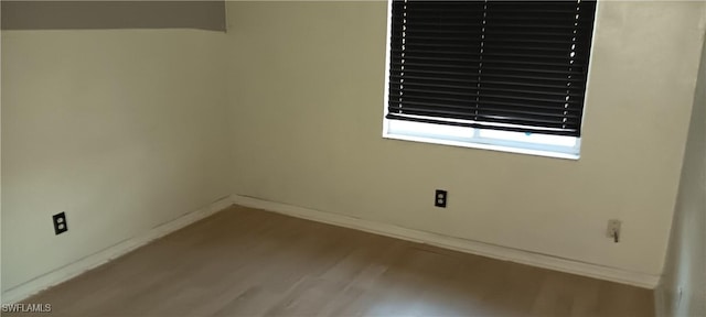 spare room with wood finished floors and baseboards