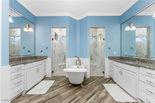 bathroom with plus walk in shower, vanity, crown molding, and hardwood / wood-style floors