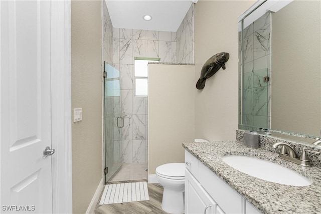 bathroom with toilet, wood-type flooring, an enclosed shower, and vanity