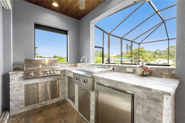 view of patio with an outdoor kitchen, a grill, and glass enclosure