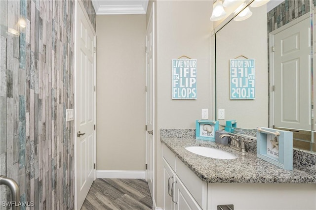 bathroom with vanity, crown molding, and wood-type flooring