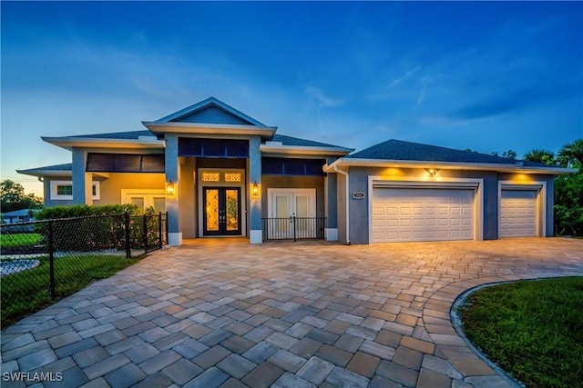 prairie-style house featuring french doors and a garage