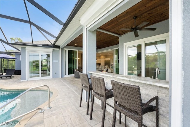 exterior space with ceiling fan, exterior bar, and a lanai