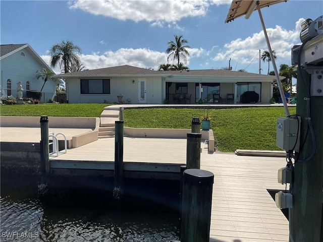 dock area with a yard and a water view