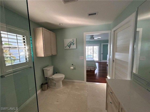 bathroom with toilet, vanity, and ceiling fan