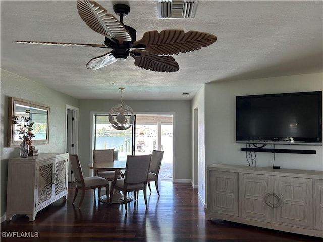 dining area with a textured ceiling, dark hardwood / wood-style floors, and ceiling fan with notable chandelier