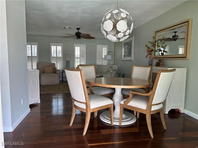 dining space featuring ceiling fan with notable chandelier and dark hardwood / wood-style floors