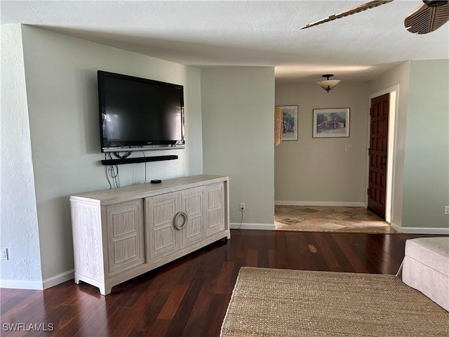 unfurnished living room with dark wood-type flooring and a textured ceiling