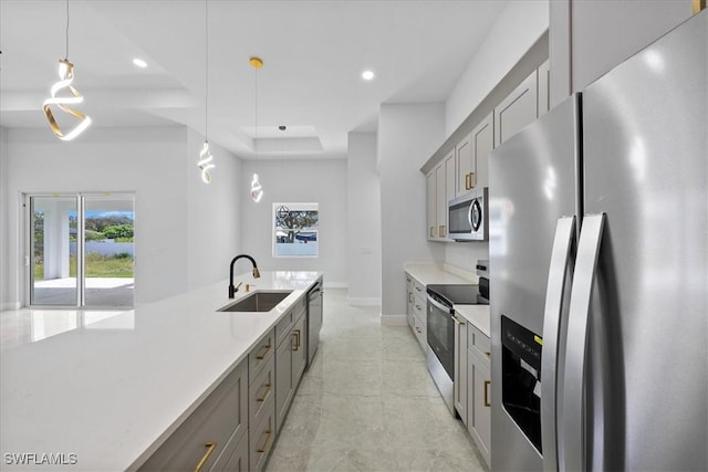kitchen with appliances with stainless steel finishes, sink, pendant lighting, and gray cabinetry