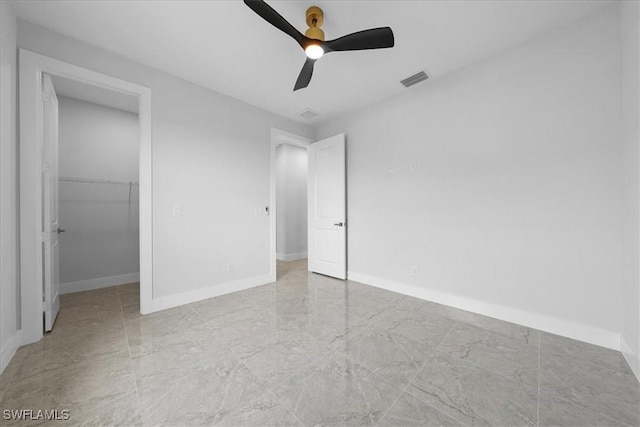 unfurnished bedroom featuring a walk in closet, ceiling fan, and a closet