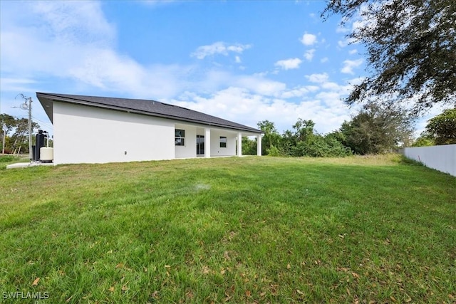 rear view of property featuring a yard