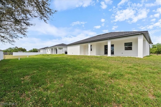 back of house with a lawn