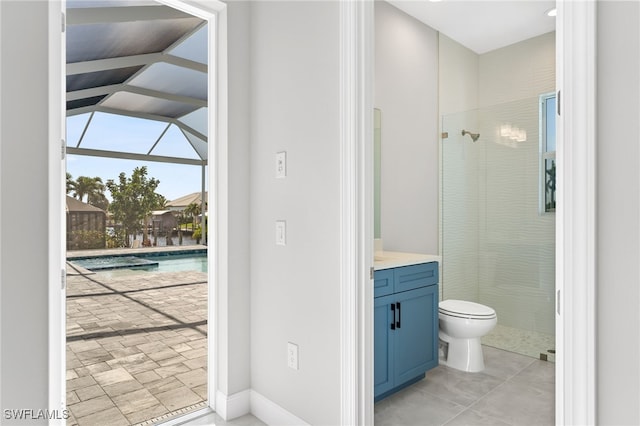 bathroom featuring tile patterned floors, tiled shower, vanity, and toilet