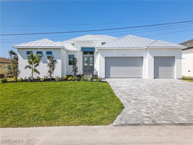 view of front of property featuring a garage, french doors, and a front yard