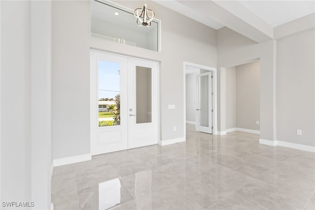 foyer featuring a notable chandelier and french doors