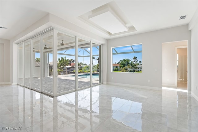 spare room with a raised ceiling and ceiling fan