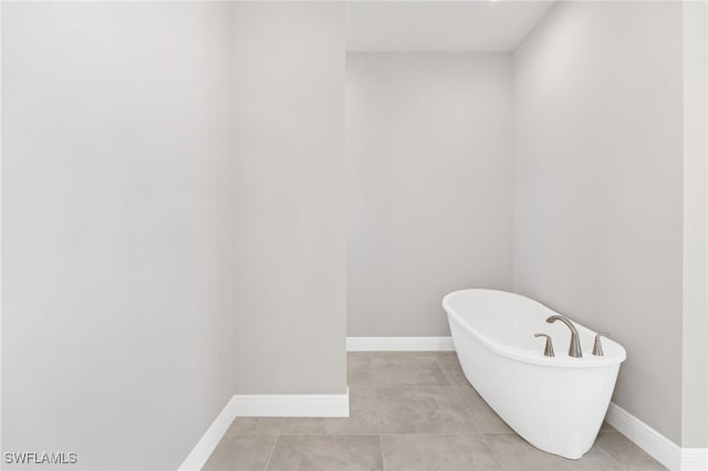 bathroom with tile patterned floors and a washtub